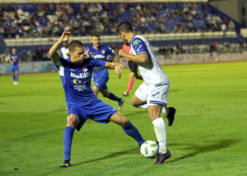 Uno de los jugadores de la escuadra melillense, en la lucha por un balón, con un jugador rival.