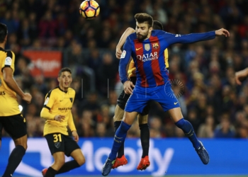 Gerard Piqué remata de cabeza en el encuentro de ayer frente al Málaga CF, que terminó con empate sin goles.