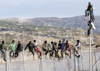 GRA039 MELILLA, 03/04/2014.- Unos 25 inmigrantes de origen subsahariano permanecen encaramados en la parte alta de la valla de Melilla y forman parte de un grupo que ha intentado acceder a la ciudad autónoma sobre las 09.00 horas. Los inmigrantes están en la zona de Aguadú, la parte más al norte del perímetro de Melilla. EFE/Neupic/Juan Ríos