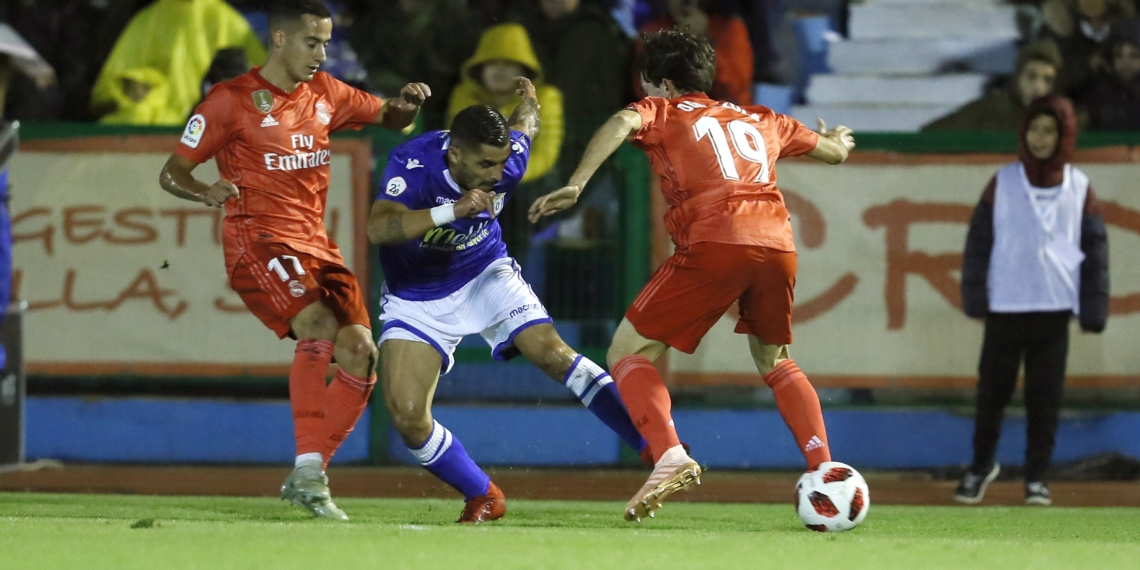 GRAF9211. MELILLA, 31/10/2018.- El centrocampista del Melilla Juan Ramón Ruano (c) con el balón ante los jugadores del Real Madrid Lucas Vázquez (i) y Álvaro Odiozoloa durante el partido de dieciseisavos de final de la Copa del Rey disputado hoy en el estadio Álvarez Claro de Melilla. EFE/Jose Manuel Vidal