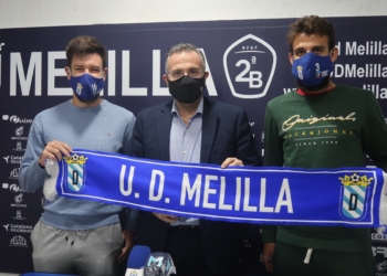 Iker Hernández y Sergio Parla sostienen, junto al presidente de la entidad azulina, una bufanda de la Unión Deportiva Melilla.