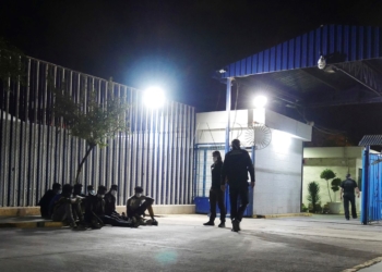 MELILLA, 13/10/2021.- Varios migrantes de origen subsahariano permanecen bajo vigilancia policial tras acceder a Melilla saltando el perímetro fronterizo entre España y Marruecos, en la madrugada de este miércoles. EFE/Paqui Sánchez