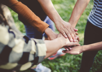 Stacking hands of young teen student, teamwork, togetherness and cooperation concept