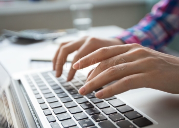 Cropped view of person hands typing on laptop computer