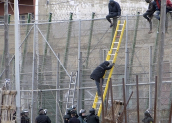 GRA122. MELILLA, 10/02/2015.- Varios de los inmigrantes encaramados a la valla de Melilla han decidido bajarse, tras permanecer en ella varias horas. Una decena de inmigrantes han permanecido encaramados en la valla de Melilla, en la zona del puesto fronterizo del Barrio Chino, donde hay un fuerte despliegue de la Guardia Civil, después de que un grupo de unos veinte subsaharianos haya conseguido acceder a la ciudad autónoma, en una noche en la que unas 400 personas, organizadas en grupos, han realizado varios conatos de salto en el perímetro fronterizo. EFE/Francisco Gª Guerrero