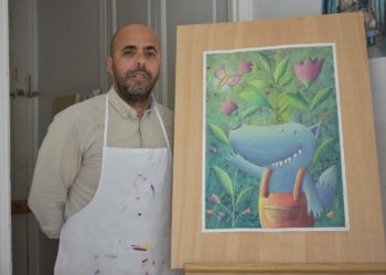 El artista Salah Mezian con una de sus ilustraciones infantiles.