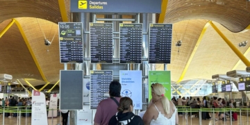 MADRID, 19/07/2024.- Varias personas miran las pantallas de información de la T-4 del Aeropuerto Adolfo Suárez de Madrid tras la incidencia global de Microsoft que ha afectado a numerosas empresas en todo el mundo. Aena ha informado de que está ya recuperando algunos de sus sistemas y que todos los aeropuertos están operativos, aunque en algunos procesos se opera con más lentitud.  EFE/ Daniel Cons